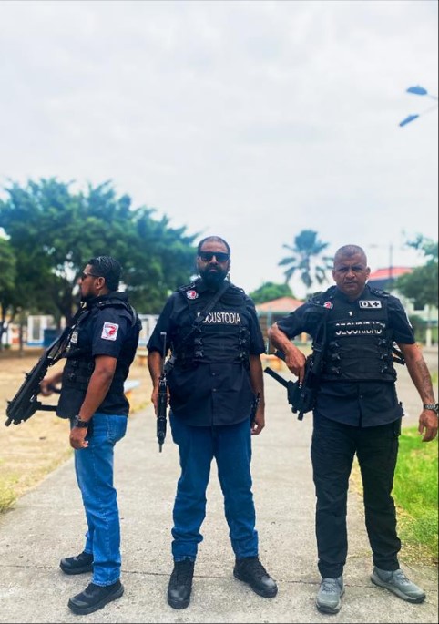Agente de custodia de First Defense de pie junto al vehículo de escolta