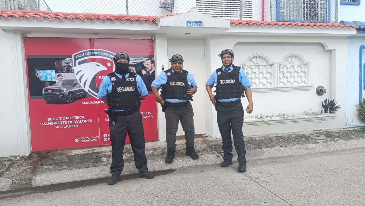Tres guardias de First Defense con chalecos frente a la sede de la empresa en Guayaquil